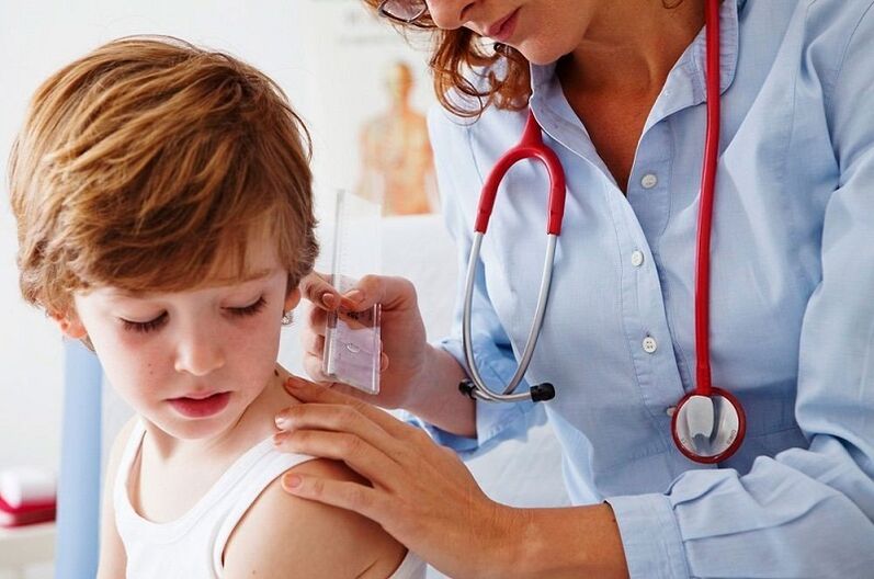 médecin examine un enfant atteint de papillome sur le corps